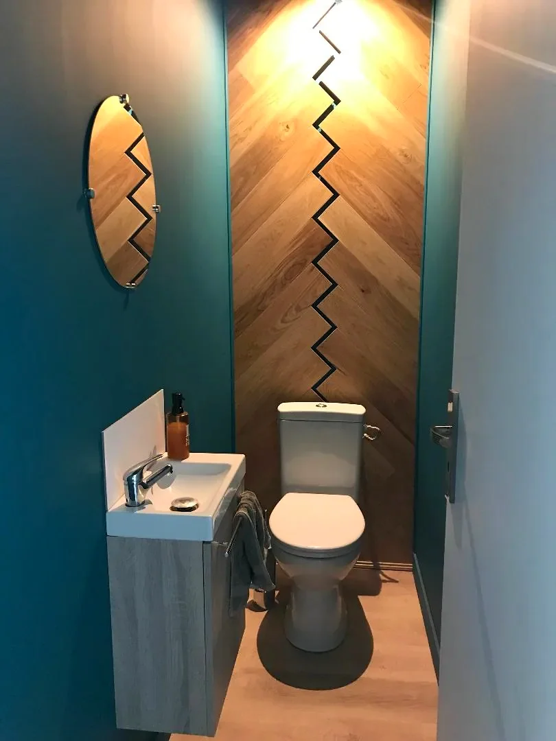 WC aux murs bleu canard et mur de bois en chevrons