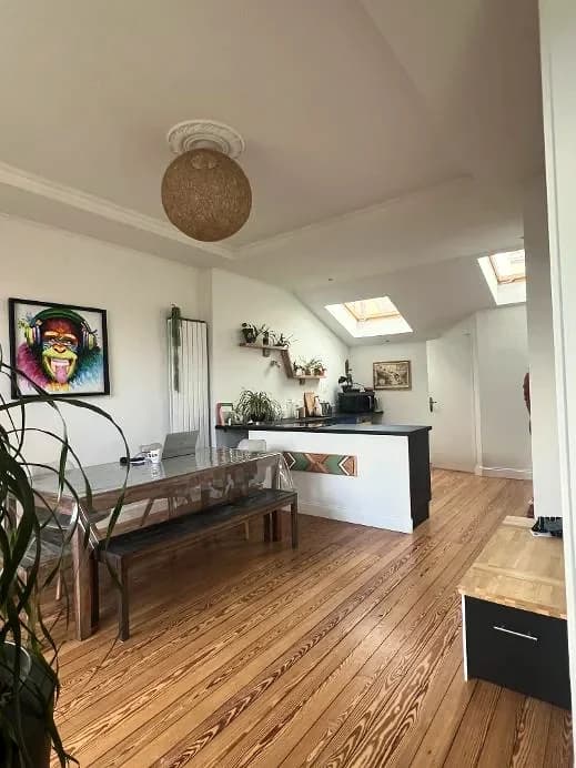 Séjour ouvert sur une cuisine sous combles, parquet ancien