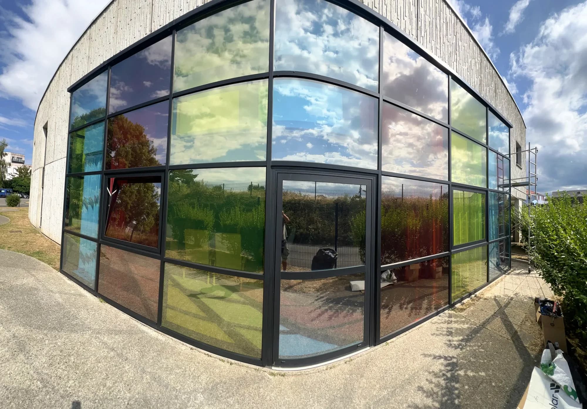 Façade courbe dont les panneaux vitrés jouent des reflets colorés